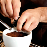 **Prompt:** A close-up shot of an Italian barista's hands meticulously tamping freshly ground coffee into a portafilter, with a classic, gleaming brass espresso machine in the background. The scene is set in an authentic, bustling Italian cafe, with soft, warm lighting emphasizing the artistry and precision. Details like coffee dust, focused expression, and the texture of the tamped coffee should be prominent. Cinematic, hyperrealistic, shallow depth of field.